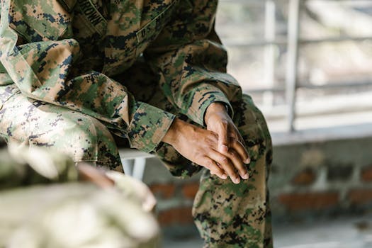 pexels-photo-7467847-7467847 Detail view of a soldier's hands and uniform showing focus and honor.